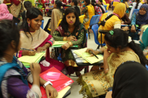 women at desk gathered in a circle